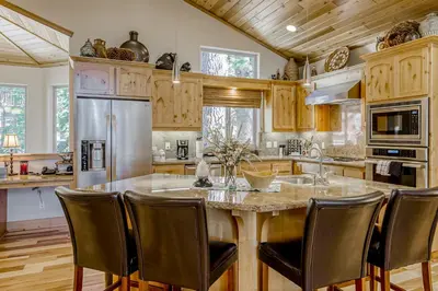 a kitchen with a large island with leather chairs at Tahoe Discovery in South Lake Tahoe