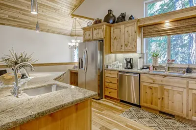a kitchen with wooden cabinets and a stainless steel refrigerator at Tahoe Discovery in South Lake Tahoe