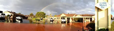 a rainbow in the middle of a town with a street at FairBridge Inn & Suites Gateway to Yosemite in Merced