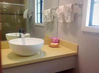 a bathroom with a large white bowl sink on a counter at FairBridge Inn & Suites Gateway to Yosemite in Merced