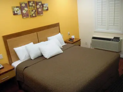 a bedroom with a large bed with white pillows at FairBridge Inn & Suites Gateway to Yosemite in Merced
