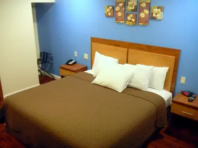 a bedroom with a large bed with white pillows at FairBridge Inn & Suites Gateway to Yosemite in Merced