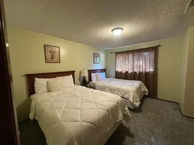 a hotel room with two beds and a window at The River Inn in Three Rivers