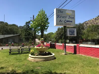 a sign for the river inn and cottages in victory at The River Inn in Three Rivers