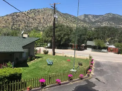 a yard with flowers and a fence with a bench at The River Inn in Three Rivers
