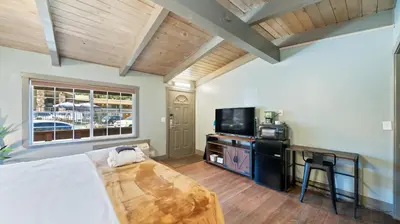 a bedroom with a bed and a tv and a window at Blue Jay Lodge in South Lake Tahoe