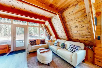 a living room with white furniture and wooden walls at The Regal Bear in Homewood