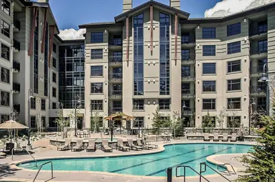 a large building with a swimming pool in front of it at Village Monache #309 condo in Mammoth Lakes