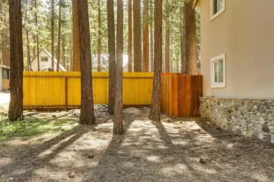 a fence and trees in front of a house at Welcoming South Lake Tahoe Rental Near Beaches in South Lake Tahoe