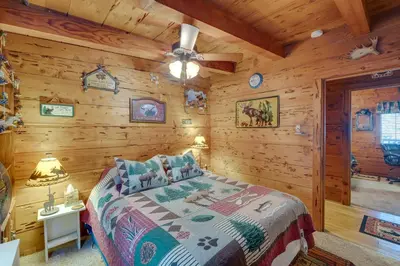 a bedroom with a bed in a log cabin at Creekside Cabin By Calaveras Big Trees State Park in Camp Connell