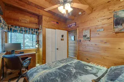 a bedroom with a bed and a desk and a computer at Creekside Cabin By Calaveras Big Trees State Park in Camp Connell