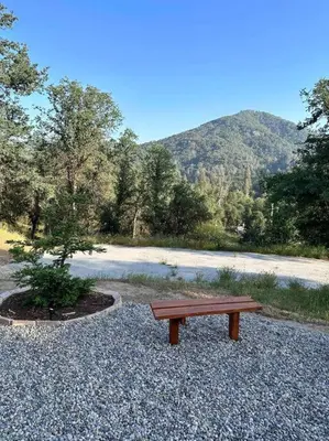a wooden bench sitting on top of a pile of gravel at Modern House on 5 acr in Sequoia National Forest in Panorama Heights
