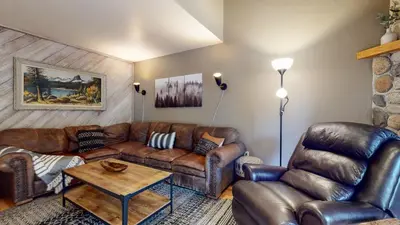 a living room with a leather couch and a table at La Vista Blanc #16 condo in Mammoth Lakes
