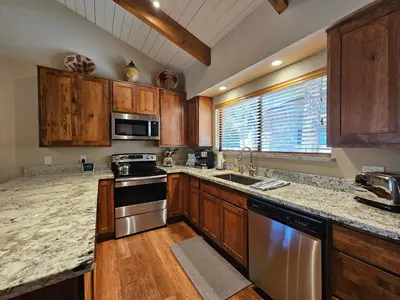 a kitchen with wooden cabinets and stainless steel appliances at Cozy Bear Lodge home in Incline Village