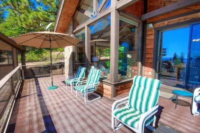 a group of chairs and an umbrella on a porch at Inclining View home in Incline Village