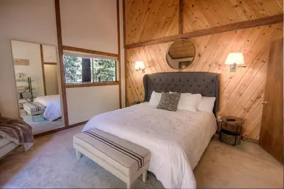 a bedroom with a large bed in a room with wooden walls at Inclining View home in Incline Village