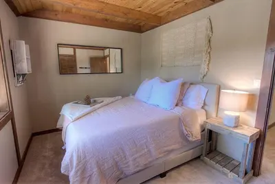 a bedroom with a bed with a mirror and a table at Inclining View home in Incline Village