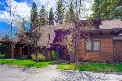 a wooden house with a tree in front of it at Third Creek Comfort townhouse in Incline Village