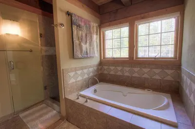 a large bathroom with a tub and a window at Third Creek Comfort townhouse in Incline Village