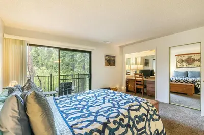 a bedroom with a bed and a balcony at 2BR Townhome Walk to Beach or Trails in Carnelian Bay