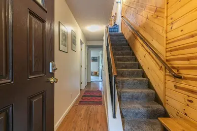 a staircase in a house with a wooden wall at 2BR Townhome Walk to Beach or Trails in Carnelian Bay