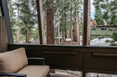 a porch with a chair and a window with trees at Tyrolean Village 6 2 Bedroom 1 and a Half Bath Sleeps 6 Walk to Lift Steps to town shuttle in Mammoth Lakes