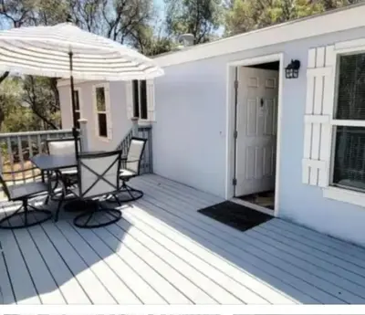 a deck with a table and chairs and an umbrella at Blue Mountainview in Mariposa