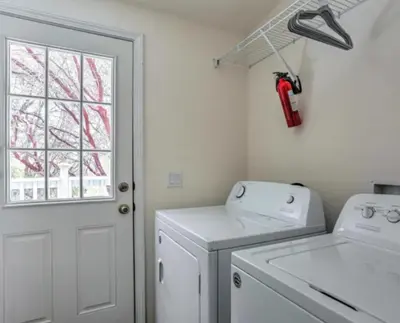a white laundry room with a washing machine and a window at Blue Mountainview in Mariposa