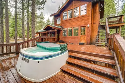 a boat sitting on a deck next to a house at Deck with Hot Tub Serene Cabin in Truckee in Truckee
