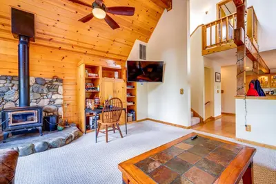 a living room with a fireplace and a stone wall at Deck with Hot Tub Serene Cabin in Truckee in Truckee