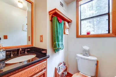 a bathroom with a sink and a toilet and a mirror at Deck with Hot Tub Serene Cabin in Truckee in Truckee