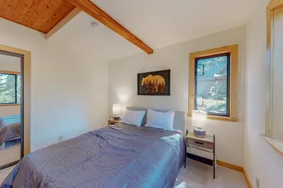 a bedroom with a blue bed and two windows at Epic Mountain Escape in Tahoe Vista