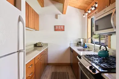 a kitchen with a stove top oven next to a sink at Bright 2BDR Next to NorthStar - 5min Walk! in Truckee