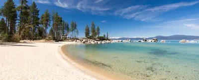a beach with trees and the water and the sky at Bright 2BDR Next to NorthStar - 5min Walk! in Truckee