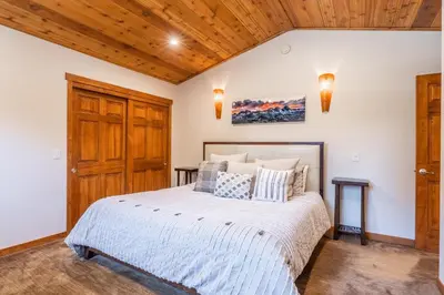 a bedroom with a large bed and wooden ceilings at Grayfox #4 3 Bedroom 3 Bathroom Sleeps 8 Walk to Village Gondola in Mammoth Lakes