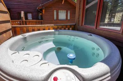 a jacuzzi tub in front of a cabin at Grayfox #4 3 Bedroom 3 Bathroom Sleeps 8 Walk to Village Gondola in Mammoth Lakes