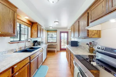 a large kitchen with wooden cabinets and a sink at Cozy and Comfortable Yosemite Portal in Oakhurst