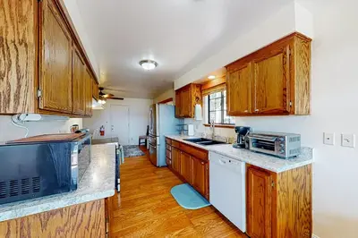 a kitchen with wooden cabinets and white appliances at Cozy and Comfortable Yosemite Portal in Oakhurst