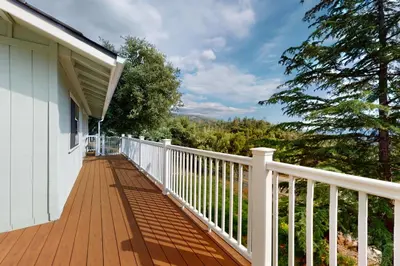 a porch of a house with a white railing at Cozy and Comfortable Yosemite Portal in Oakhurst