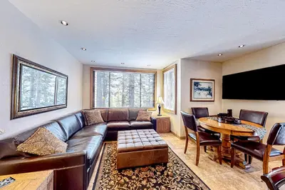 a living room with a leather couch and a table at Powder Pines Retreat in Kingswood Estates