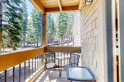 a porch with two chairs and a table on it at Powder Pines Retreat in Kingswood Estates