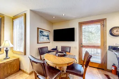 a dining room with a table and chairs and a television at Powder Pines Retreat in Kingswood Estates