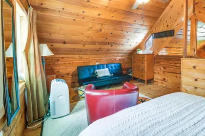 a bedroom with a bed in a wooden cabin at Fire Pit, Deck and Grill Cozy Twain Harte Cabin! in Twain Harte