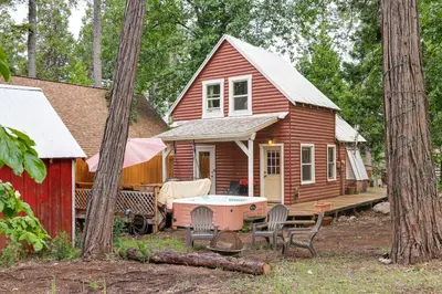 a red house with a table and chairs in front of it at Fire Pit, Deck and Grill Cozy Twain Harte Cabin! in Twain Harte
