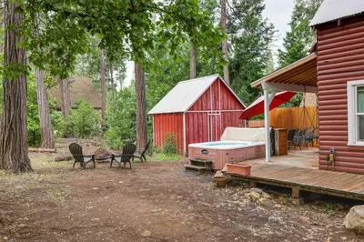 a red house with a deck and a red barn at Fire Pit, Deck and Grill Cozy Twain Harte Cabin! in Twain Harte