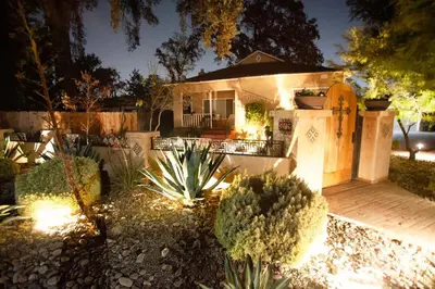 a house with lights in a yard at night at Sequoia Basecamp with Hot Tub Oasis in Visalia