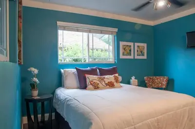 a bedroom with blue walls and a bed with pillows at Sequoia Basecamp with Hot Tub Oasis in Visalia