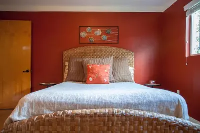 a bedroom with a large bed with red walls at Sequoia Basecamp with Hot Tub Oasis in Visalia