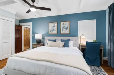 a bedroom with a large bed and a blue wall at Grape Escape Inn & Suites in Lodi