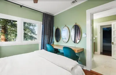 a bedroom with a bed and a desk and mirrors at Grape Escape Inn & Suites in Lodi